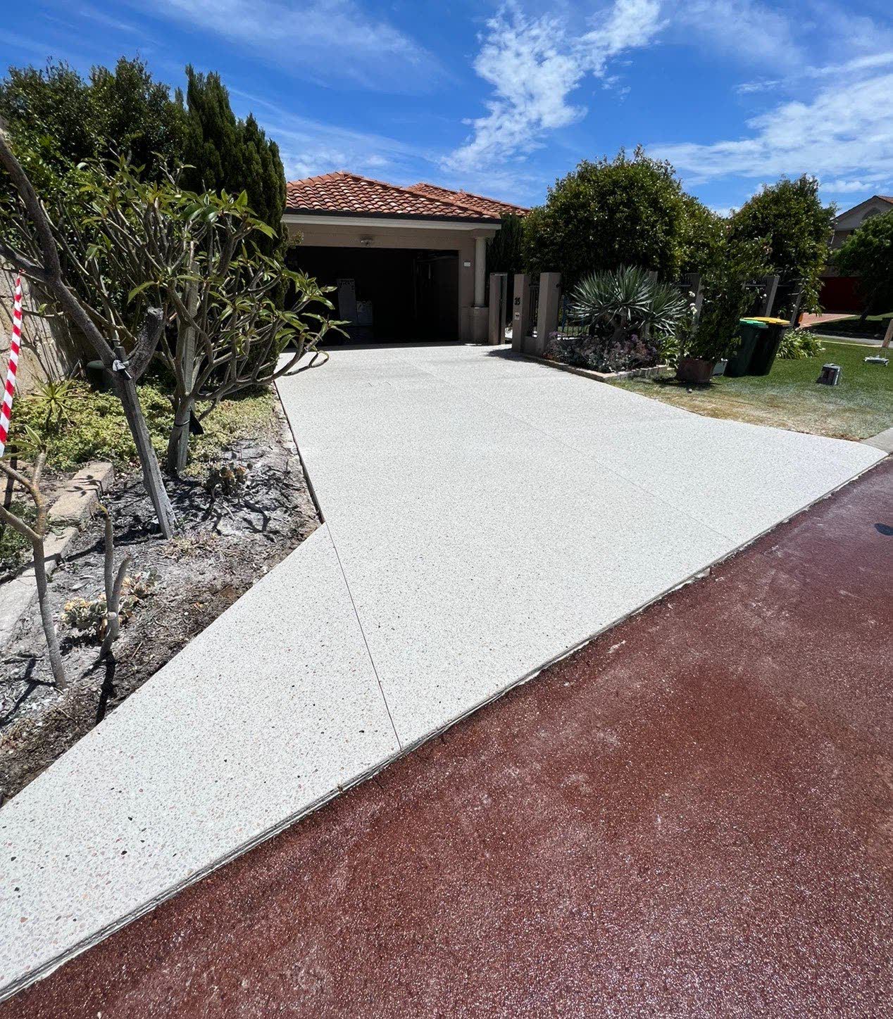 Exposed aggregate driveway from the street with coloured crossover